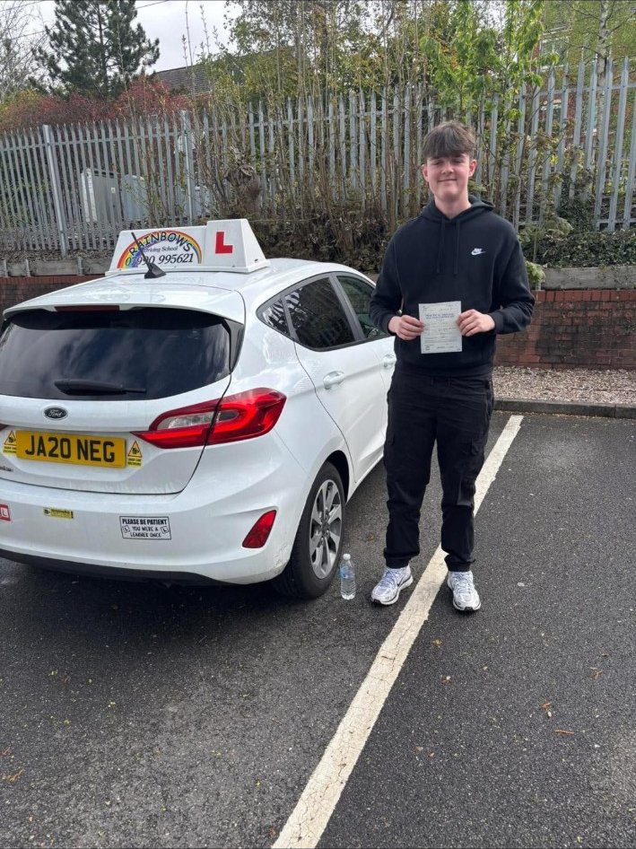 Rainbows pupil celebrating beside a learner car
